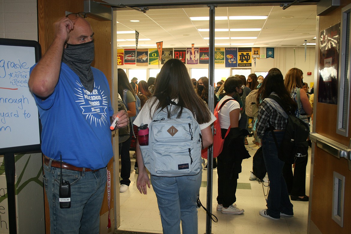 Security officer Scott Strom directs traffic on the first day of classes at Frontier Middle School Wednesday.