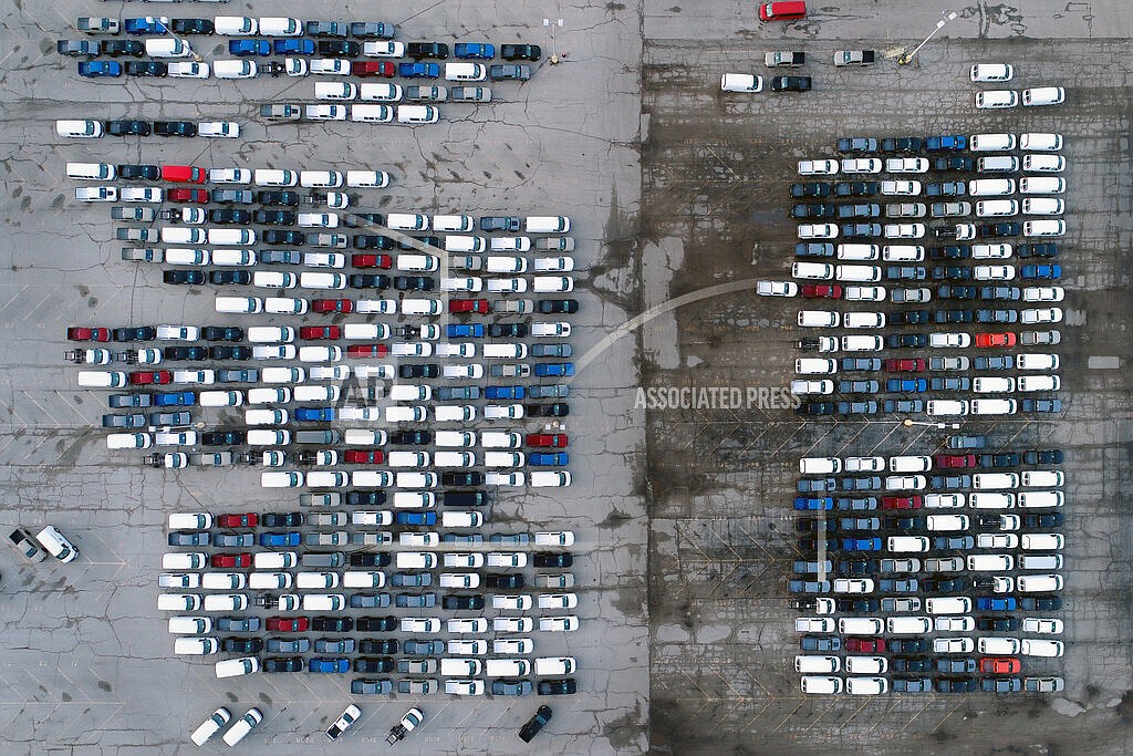 In this March 24, 2021 file photo, mid-sized pickup trucks and full-size vans are seen in a parking lot outside a General Motors assembly plant where they are produced in Wentzville, Mo. The global shortage of computer chips is getting worse, forcing automakers to temporarily close factories including those that build popular pickup trucks. General Motors announced Thursday, Sept, 2, 2021 that it would pause production at seven North American plants during the next two weeks, including two that make the company’s top-selling Chevrolet Silverado pickup. (AP Photo/Jeff Roberson, File)