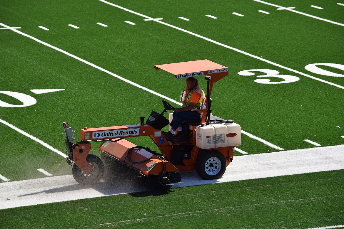 FieldTurf foreman Michael Glidden sweeps the new artificial turf at Lions Field to distribute the tons of sand and shredded rubber used to cover the field.