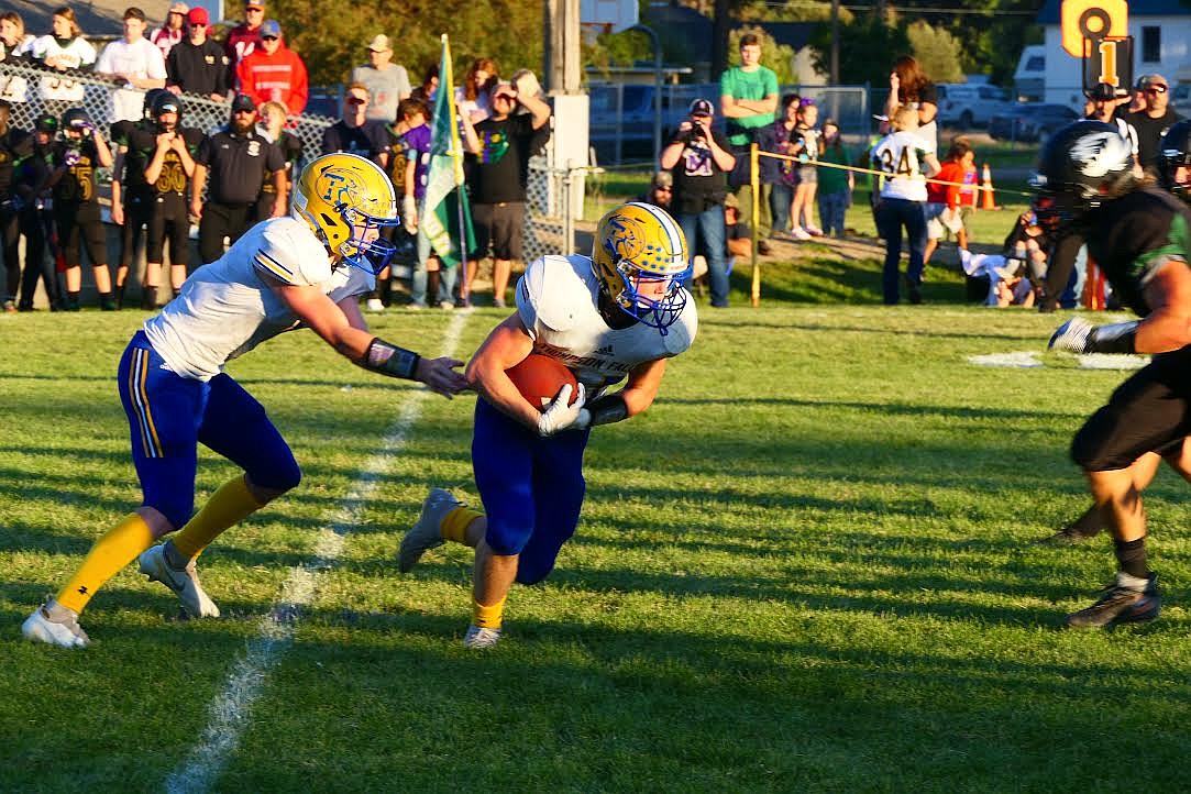 Thompson Falls quarterback Theo Ratliff hands the ball to running back Trae Thilmony in last Friday's game against St. Regis/Mullan. Both players played key roles in a 44-26 win. (Chuck Bandel/Valley Press)