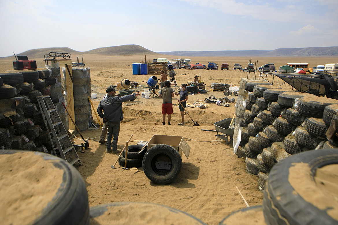 Builders work on Ruth and Bill Craven's home, known as an Earthship, Thursday, July 29, 2021, near Belfry, Mont. The couple are rebuilding on property recently overrun by a wildfire. (Ryan Berry/Billings Gazette via AP)