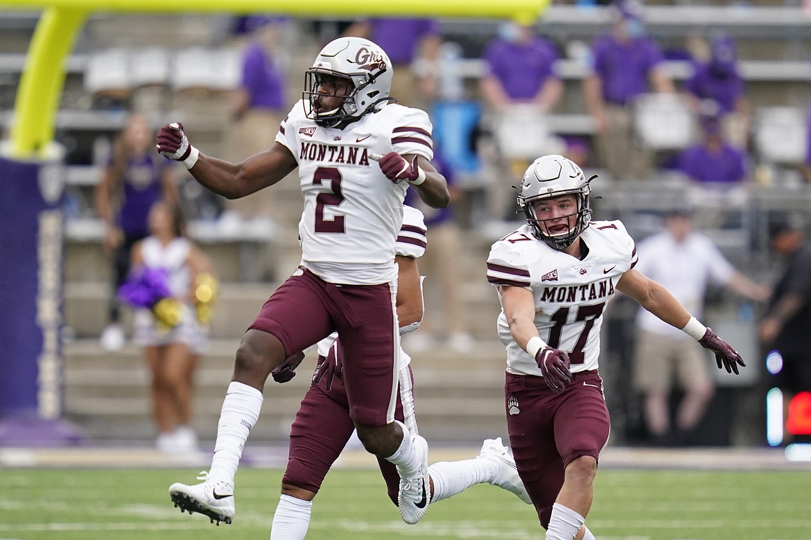 Montana's Gavin Robertson (2) leaps in celebration after making an interception against Washington as teammate Robby Hauck follows in the first half of an NCAA college football game Saturday, Sept. 4, 2021, in Seattle. (Elaine Thompson/Associated Press)