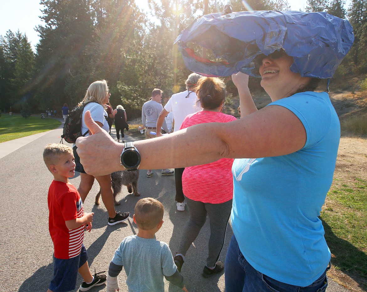 Jessicca Rude cheers people on during the Coeur d'Alene .5K fun run at McEuen Park on Saturday.