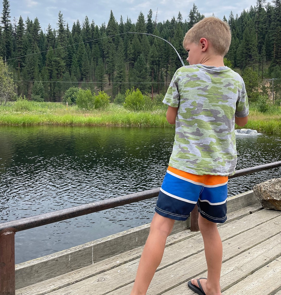 A youth fishes for trout at a pond stocked by the Idaho Department of Fish & Game.