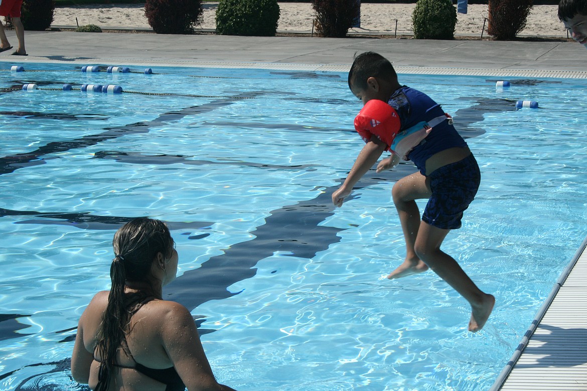 Darlan Flores jumps into the pool at the Surf ‘n Slide Water Park Sunday while his mother, Dulce Flores, watches.