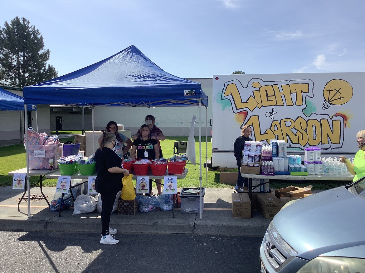 Volunteers from the Light of Larson Church hand out school supplies and backpacks to Larson Heights Elementary School students Aug. 26.