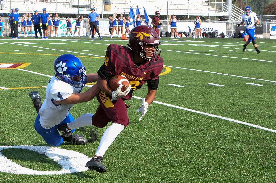 Moses Lake’s Kyson Thomas pulls away from a Bothell defender after making a catch in the first half Saturday afternoon at Lions Field.