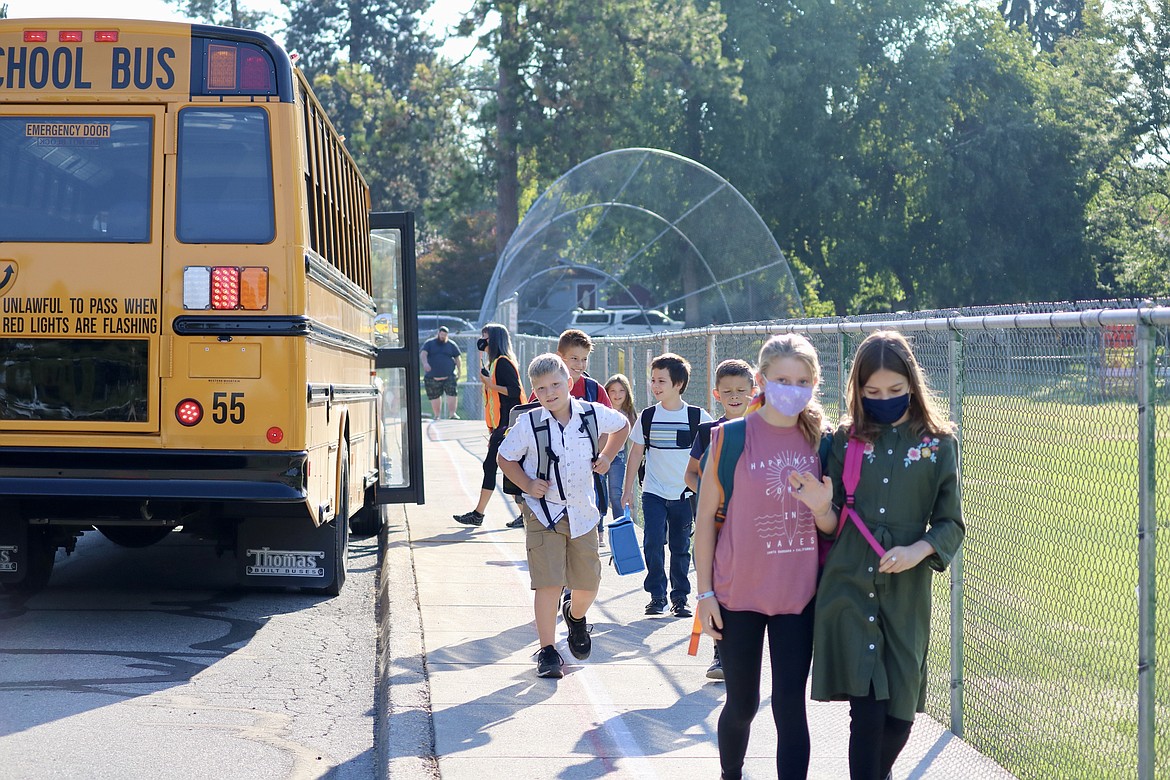 Students unload from the bus at Winton Elementary School on Tuesday morning for the first day of classes. HANNAH NEFF/Press