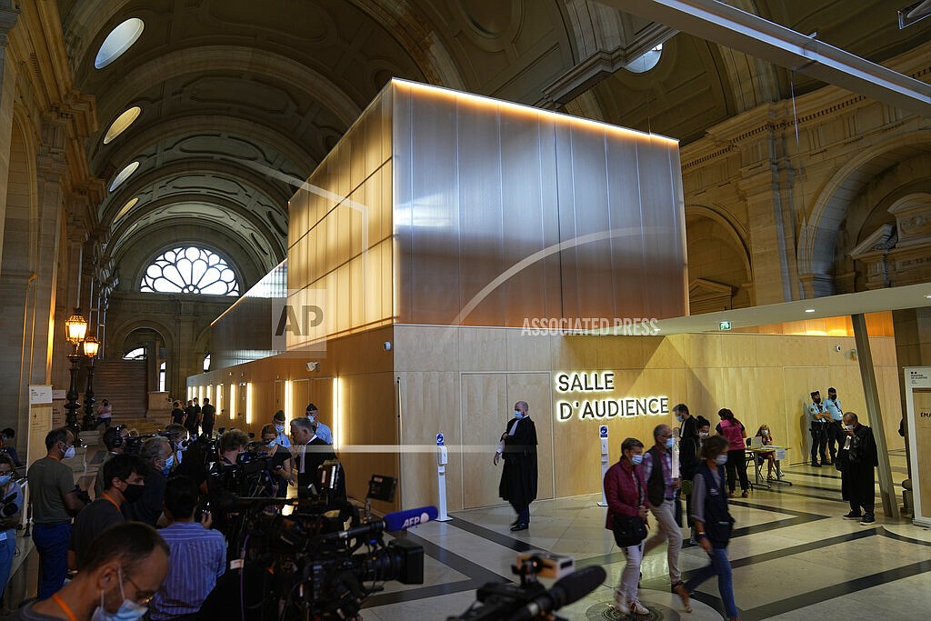 Reporters focus on the special courtroom built for the 2015 attacks trial, Wednesday, Sept. 8, 2021 in Paris. In a custom-built secure complex embedded within a 13th-century courthouse, France opened the trial of 20 men accused in the Islamic State group's 2015 attacks in Paris that left 130 people dead and hundreds injured. Nine gunmen and suicide bombers struck within minutes of each other at France's national soccer stadium, the Bataclan concert hall and Paris restaurants and cafes on Nov. 13, 2015. (AP Photo/Michel Euler)