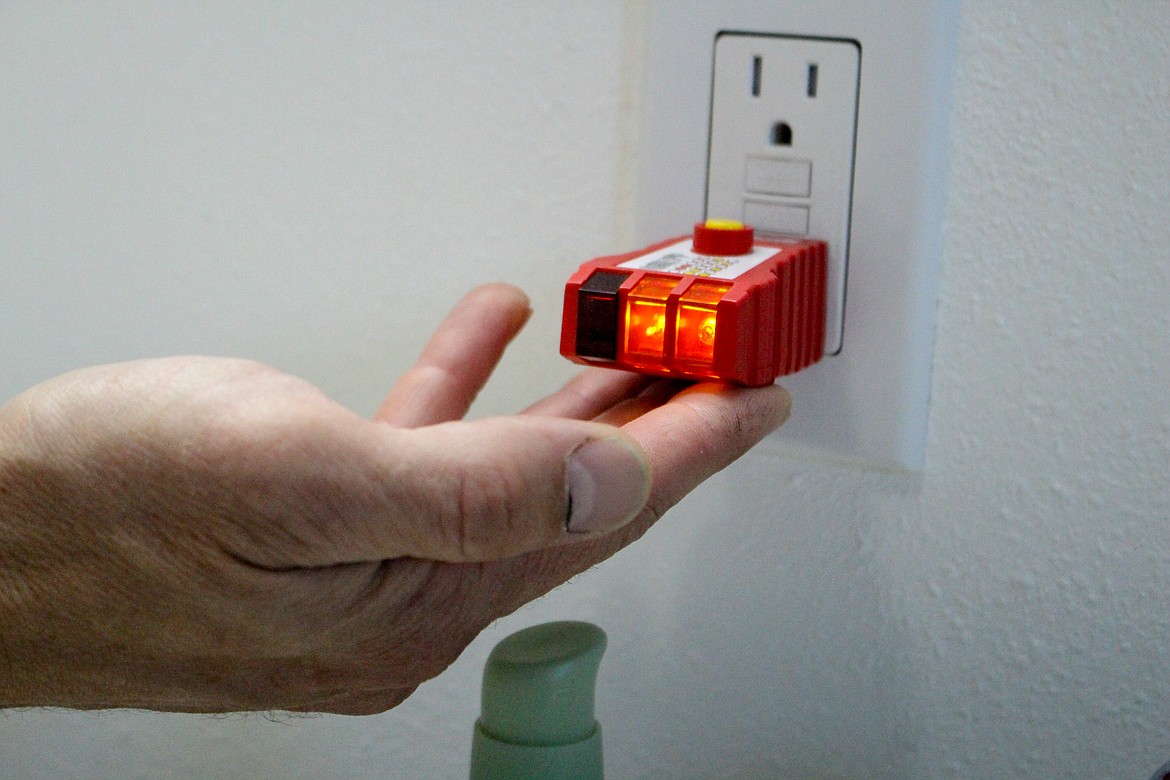 Darrel Jensen holds up an electrical outlet tester, which he uses in inspections to make sure outlets are working and wired safely and properly.