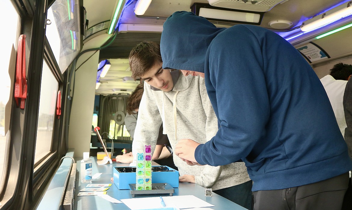 Evan Lafferty, left, a tenth grader, and Mason McCarthy, a senior, of Lake City High School work on puzzles to "escape" the Discovery Bus on Thursday in the school parking lot as part of the game design class. HANNAH NEFF/Press