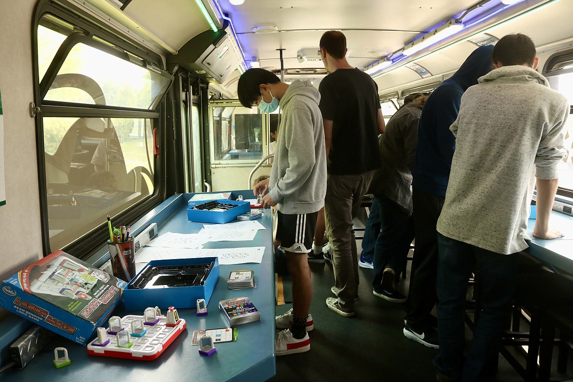 Students of Scott Jacobson's game design class at Lake City High School explore the Discovery Bus, a 60-foot educational bus owned by the Community Library Network, to find clues and solve puzzles. As part of the class, students participated in an "escape the bus" activity on Thursday in the school parking lot. HANNAH NEFF/Press