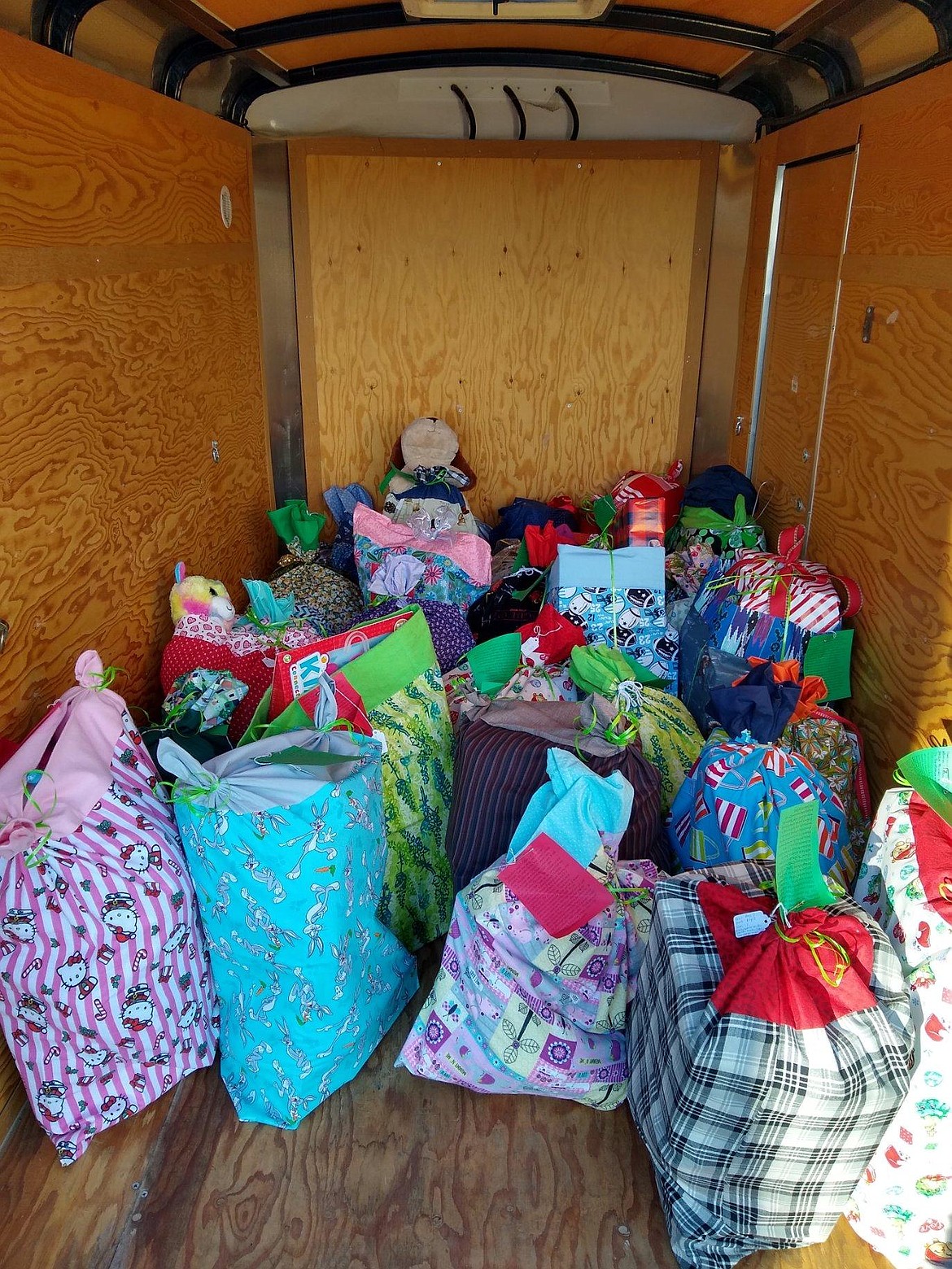 Pillowcases filled with Christmas presents for children in foster care are loaded in a trailer for delivery in December 2020.
