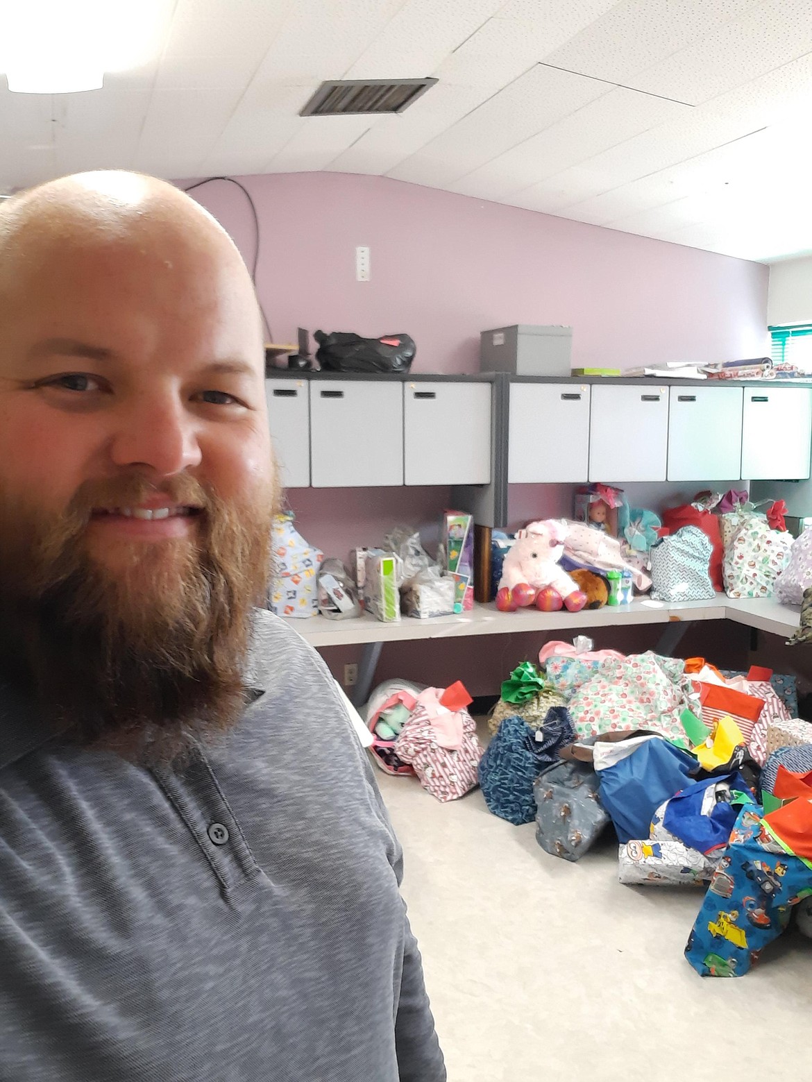 Matt Boyce snaps a selfie with pillowcases stuffed with gifts for foster children in December 2020.