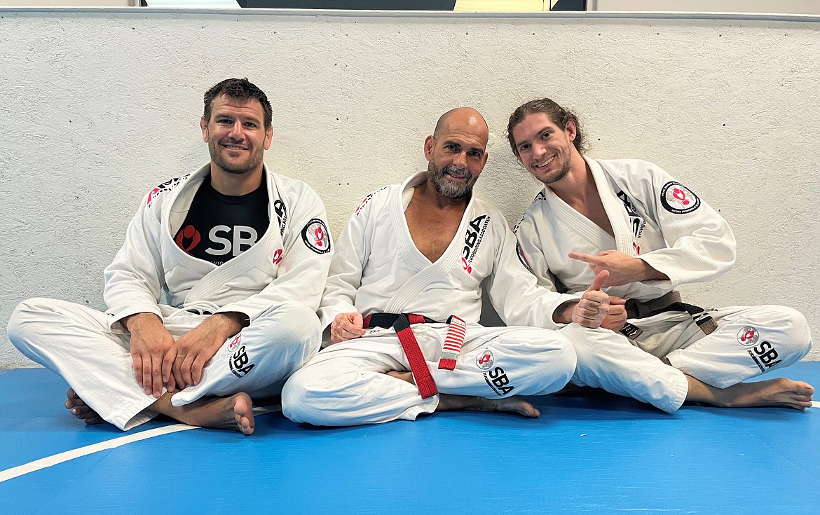 Professor Tanner Weisgram (left), Master Sylvio Behring and Lee Savage, the highest ranking student in North Idaho to receive all of his belt promotions from Master Sylvio, pose for a photo on Tuesday at SBA Ponderay.