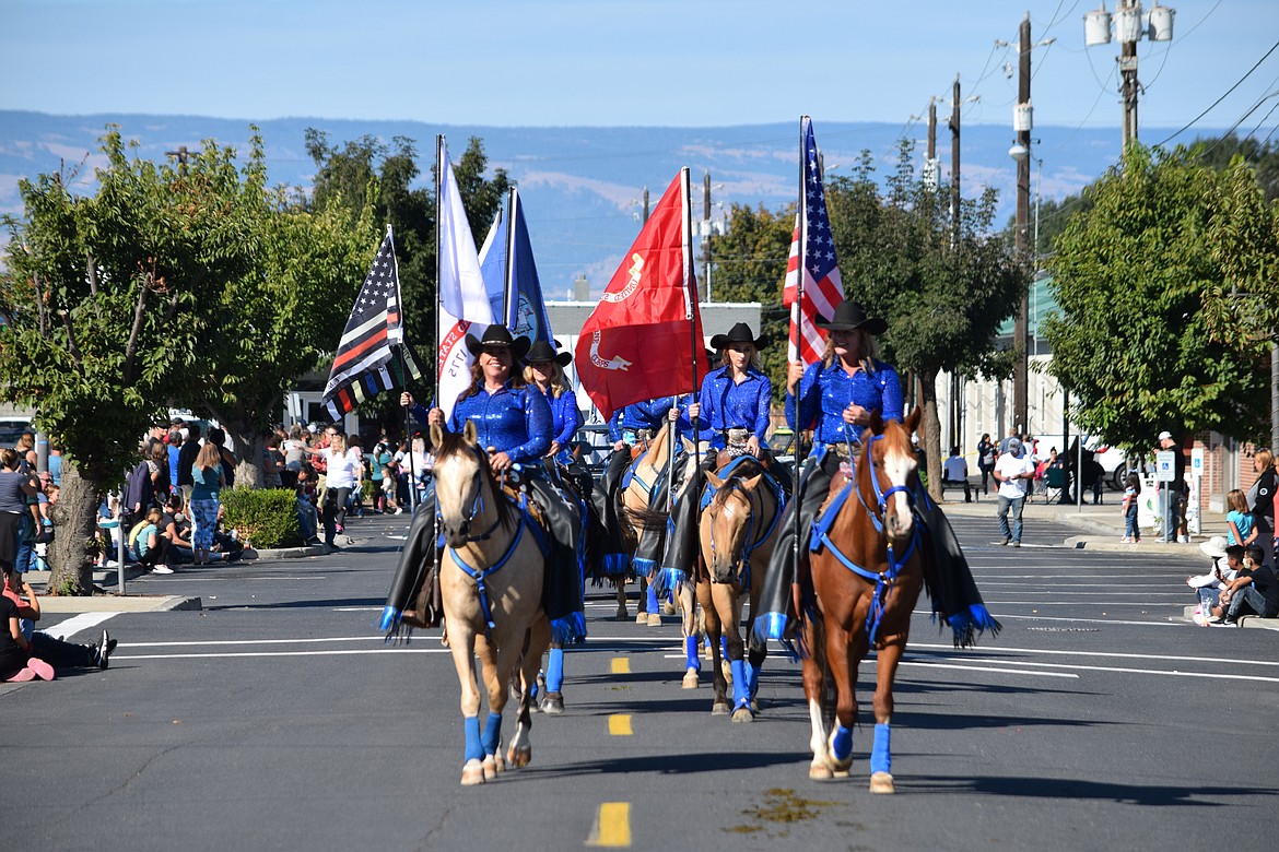 A mounted color guard honoring the U.S. military, especially the last 13 service members to die in Afghanistan, marches as part of the Farmer Consumer Awareness Day parade in Quincy on Saturday.