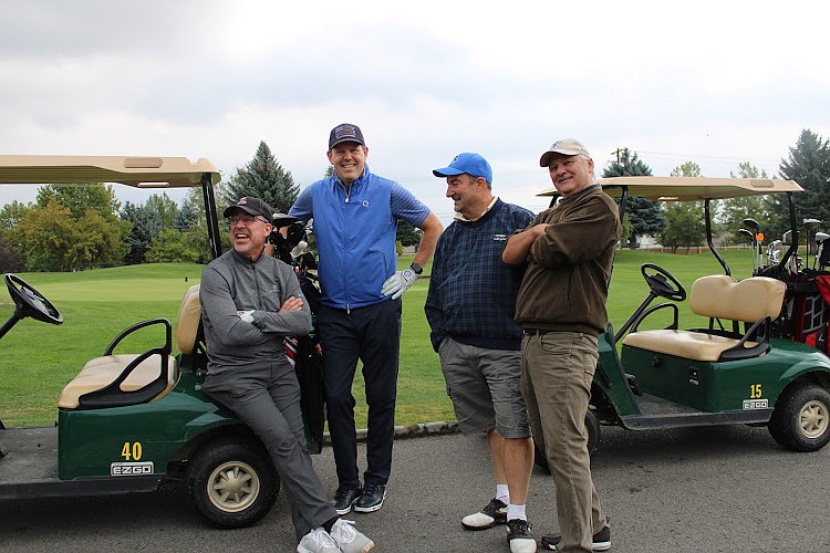Foursome teammates Mark Brinkman, Scott Magnuson, John Chuday and Ross Kerns pose for a picture while taking a break from golfing.