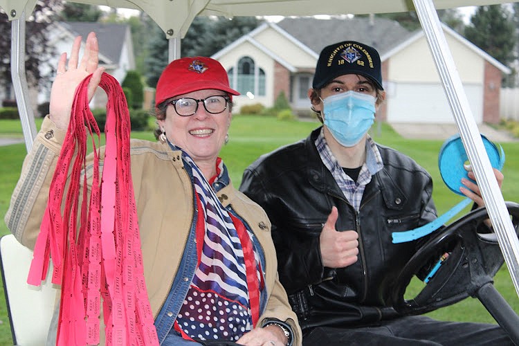 Volunteer Penni Stephens and Knight Zach Trevino sell raffle tickets along the course.