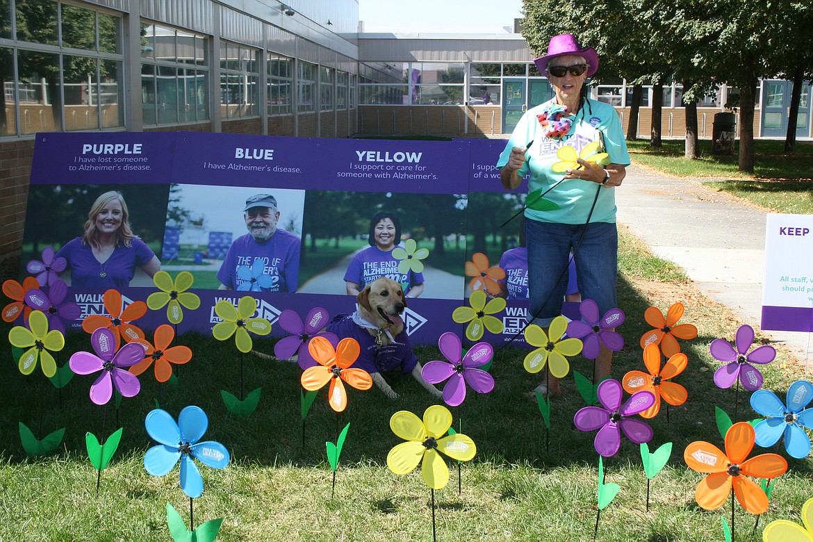 Jo Keeney and her dog Lacey hand out flower-shaped pinwheels prior to the Columbia Basin Walk to End Alzheimer’s Sunday afternoon.