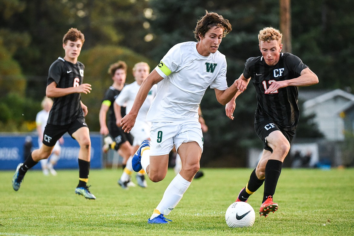 Whitefish's Gabe Menicke (9) pushes the ball upfield against Columbia Falls' Andrew Miner (12) in the first half at Columbia Falls High School on Tuesday, Sept. 14. (Casey Kreider/Daily Inter Lake)