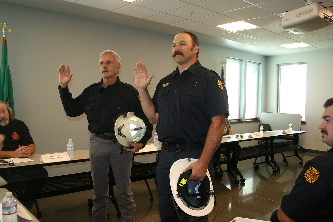 Doug Anderson (left) and Matt Hyndman take the oath of office as battalion chief during the dedication ceremony for the new Grant County Fire District 8 station Saturday.