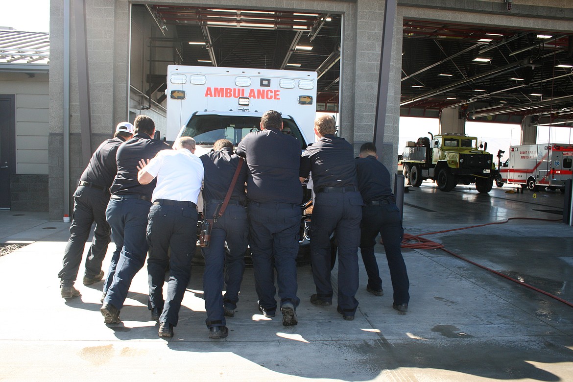 Full-time personnel of Grant County Fire District 8 push the district’s new ambulance into the fire station during the dedication of the new station Saturday.