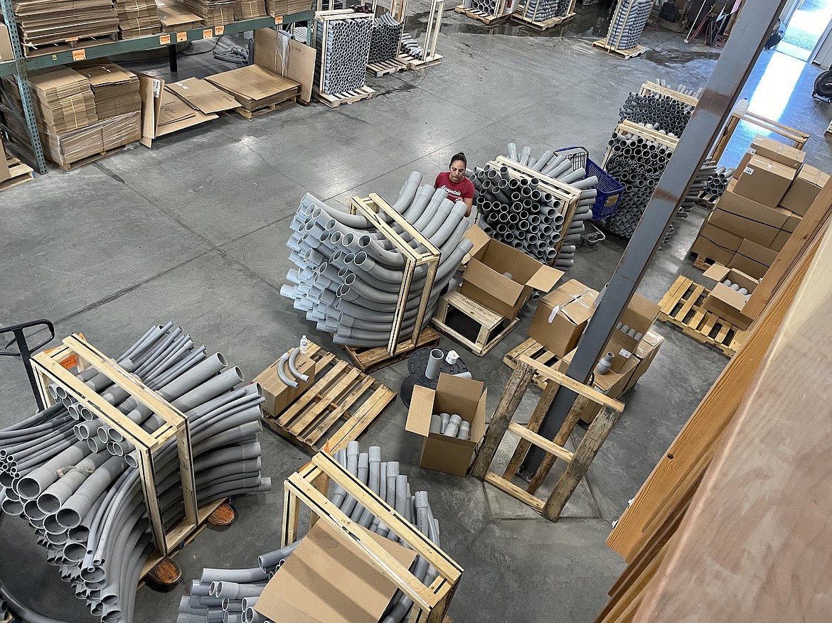 Raceways employee Karla Negrete stacks and moves curved sections of pipe known as sweeps in the company’s new Quincy factory.