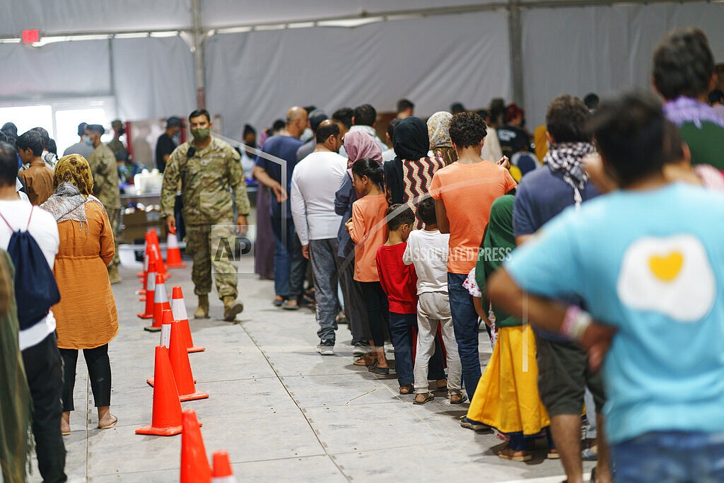 Afghan refugees line up for food in a dining hall at Fort Bliss' Doña Ana Village, in New Mexico, where they are being housed, Friday, Sept. 10, 2021. The Biden administration provided the first public look inside the U.S. military base where Afghans airlifted out of Afghanistan are screened, amid questions about how the government is caring for the refugees and vetting them. (AP Photo/David Goldman)