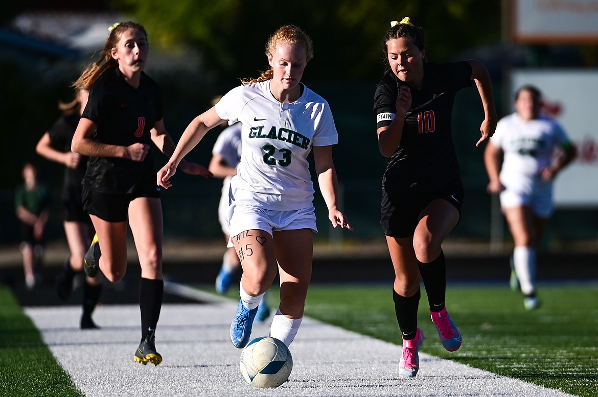 Glacier's Reese Ramey (23) pushes the ball upfield with Flathead's Ashlynn Whiteman (10) in pursuit in the first half at Legends Stadium on Thursday, Sept. 16. (Casey Kreider/Daily Inter Lake)