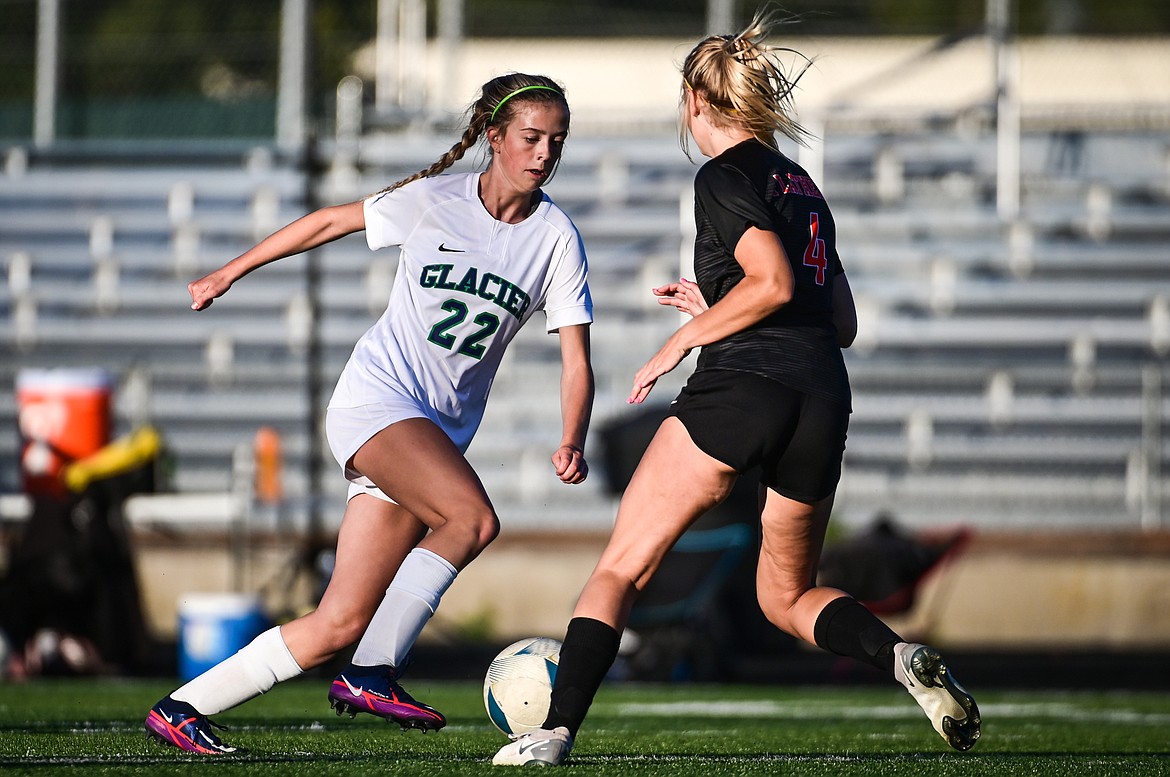 Glacier's Reagan Brisendine (22) pushes the ball upfield against Flathead's Celie Vandenbosch (4) in the first half at Legends Stadium on Thursday, Sept. 16. (Casey Kreider/Daily Inter Lake)