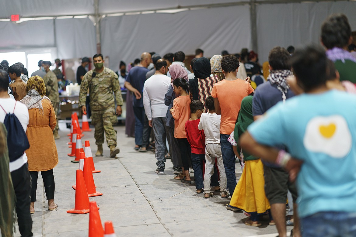 Afghan refugees line up for food in a dining hall at Fort Bliss' Doña Ana Village, in New Mexico, where they are being housed, Friday, Sept. 10, 2021. The Biden administration provided the first public look inside the U.S. military base where Afghans airlifted out of Afghanistan are screened, amid questions about how the government is caring for the refugees and vetting them. (David Goldman/Associated Press)