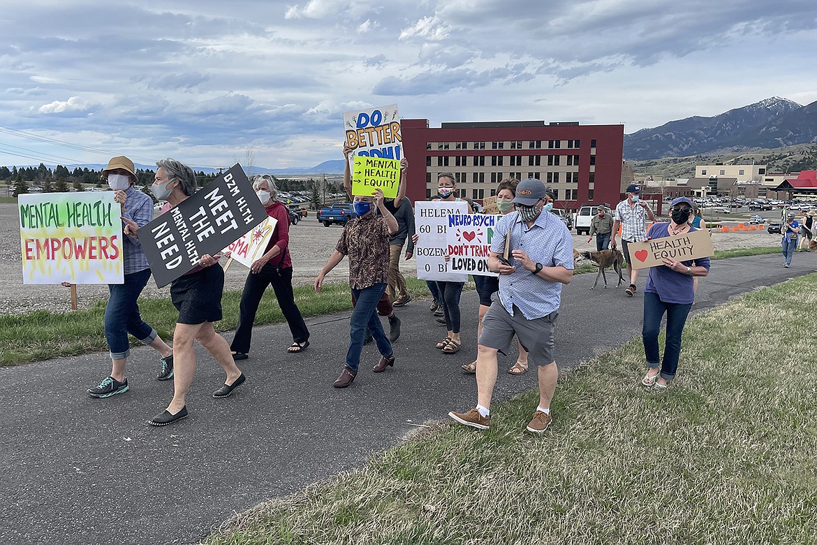 Protesters march along the sidewalk in front of Bozeman Health Deaconess Hospital to request that the health system provide inpatient psychiatric beds for those dealing with mental illness. (Olivia Weitz/Yellowstone Public Radio)