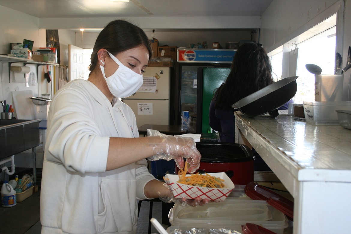 Jasmine Rincon adds the finishing touches to a spoon taco at the Sacred Heart Catholic Parish booth at the Othello Fair Thursday.