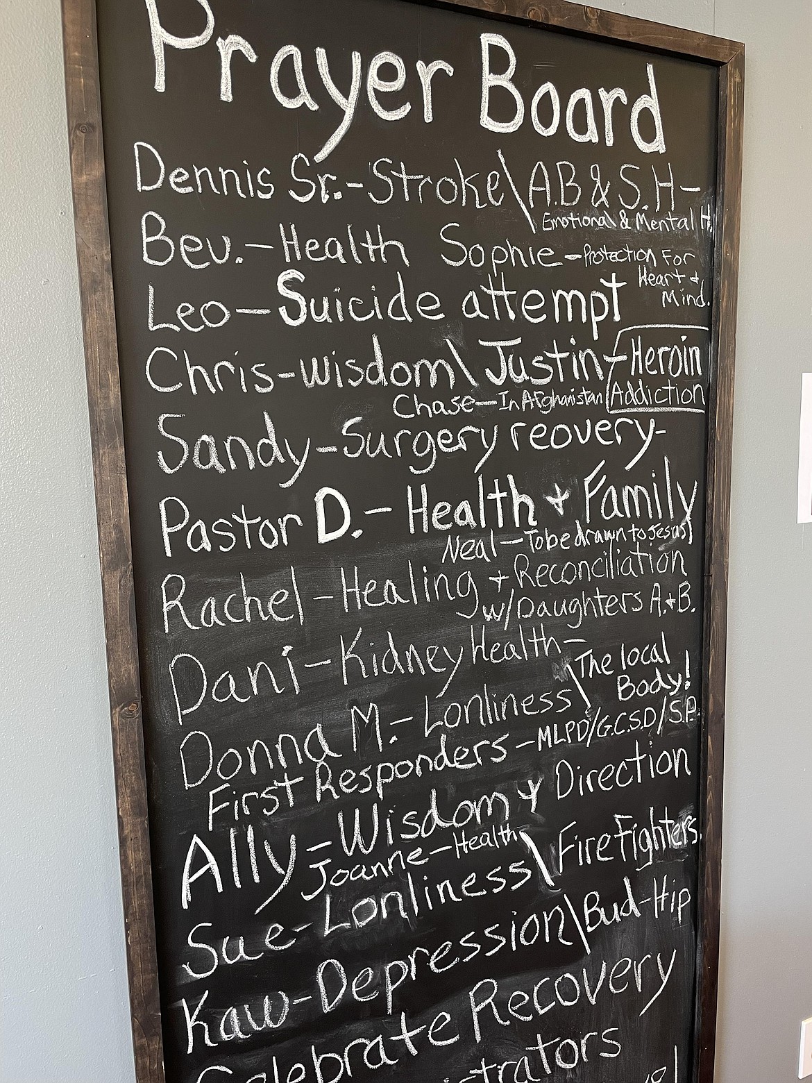 The prayer board hangs on a wall in the Red Door Cafe, which new manager Joseph Moriarty modeled after a cafe he owned and ran in Milwaukee, Wisconsin.