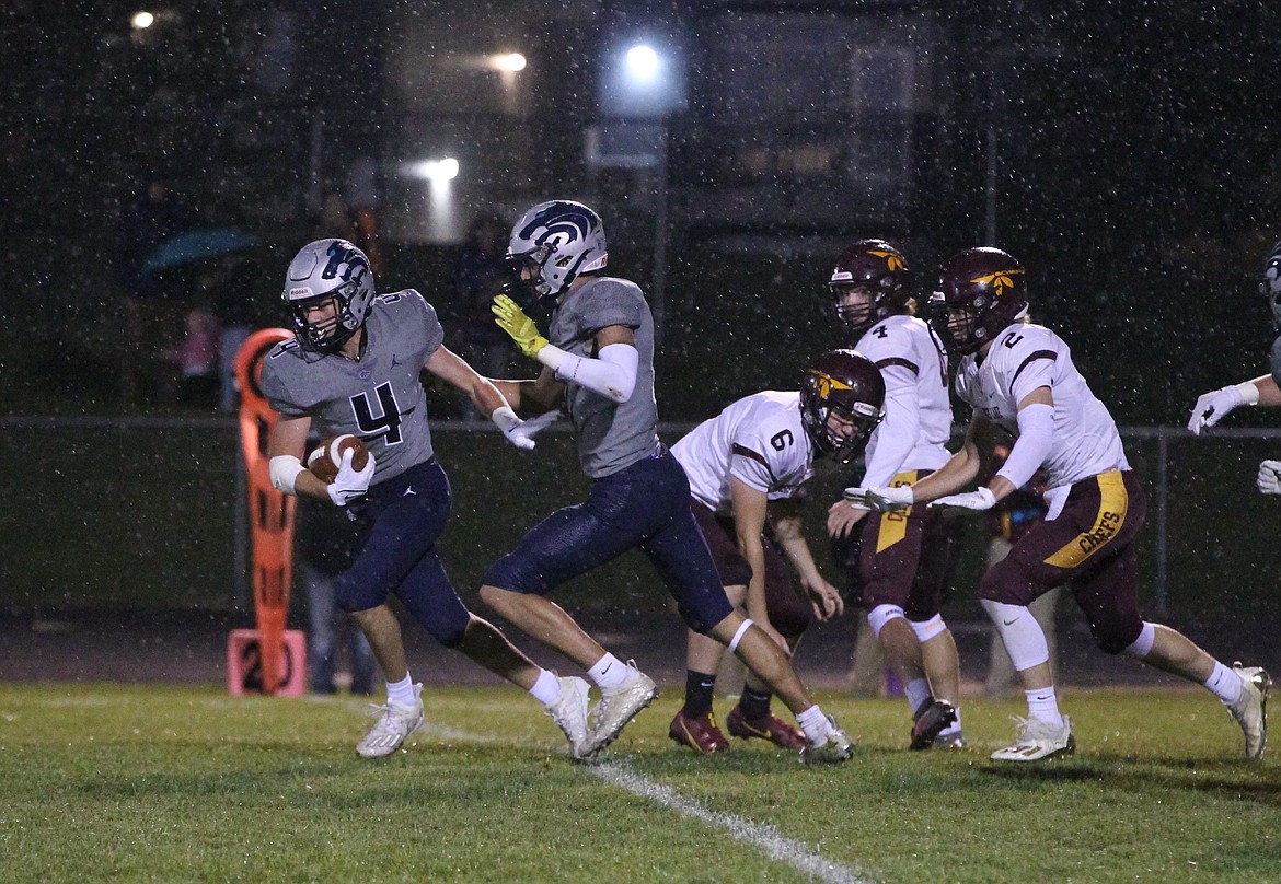 MARK NELKE/Press
Eric Bumbaugh (4) of Lake City heads for the end zone after picking up an fumbled snap from center on a Moses Lake field goal attempt late in the first half Friday night. Also pictured is Wayne Queen of Lake City, and holder Gavin Reyer (6), kicker Iden Bone (4) and Asher Lindgren (2) of Moses Lake.