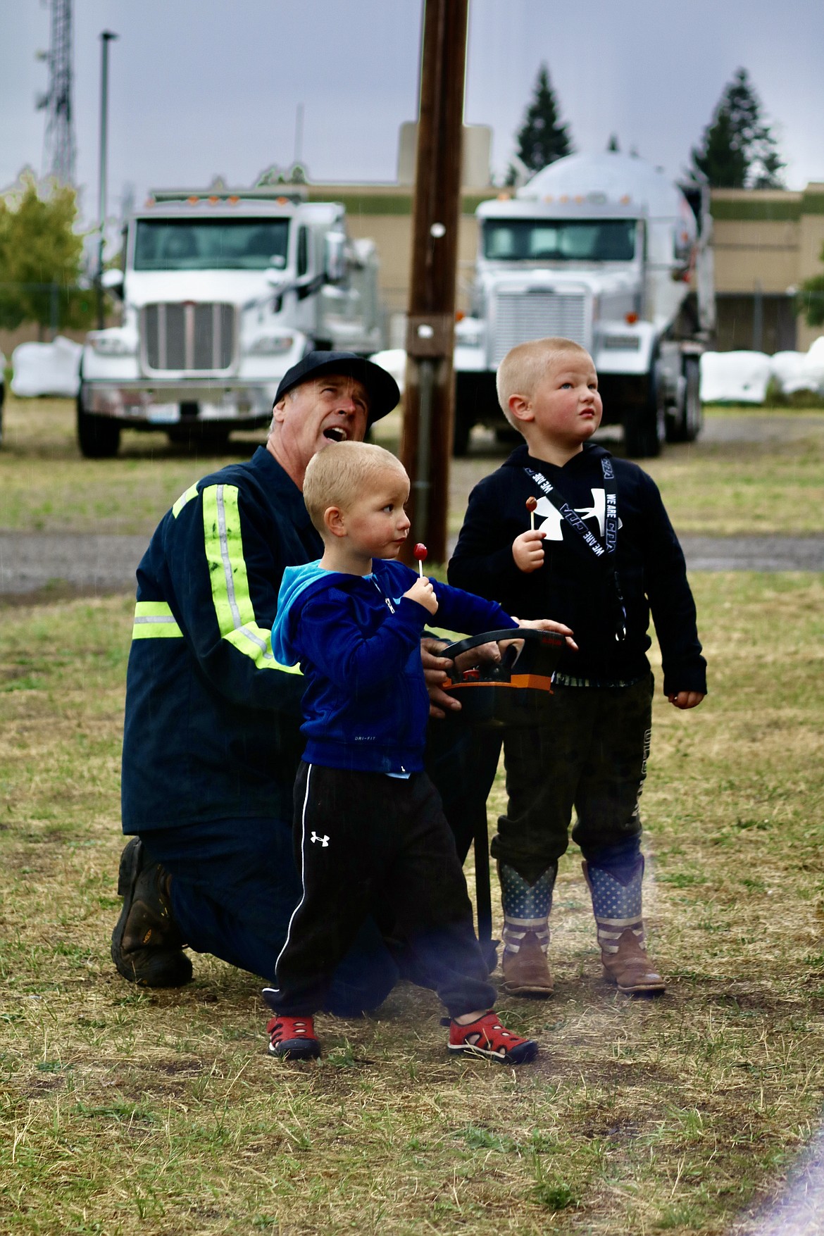 Joe Andrews, an operator for Reliable Towing, shows brothers Kade, 3, left, and Logan Abey, 4, of Post Falls how to operate the crane on the tow truck at Meet the Machines at the Kootenai County Fairgrounds on Saturday morning. HANNAH NEFF/Press