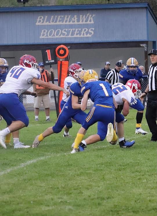 Thompson Falls’ Elijah Ratliff closes in on Superior ball carrier Chase Woodson (22) as lineman Wyatt Haworth (40) tries to intervene. (Photo courtesy Kami Millender)