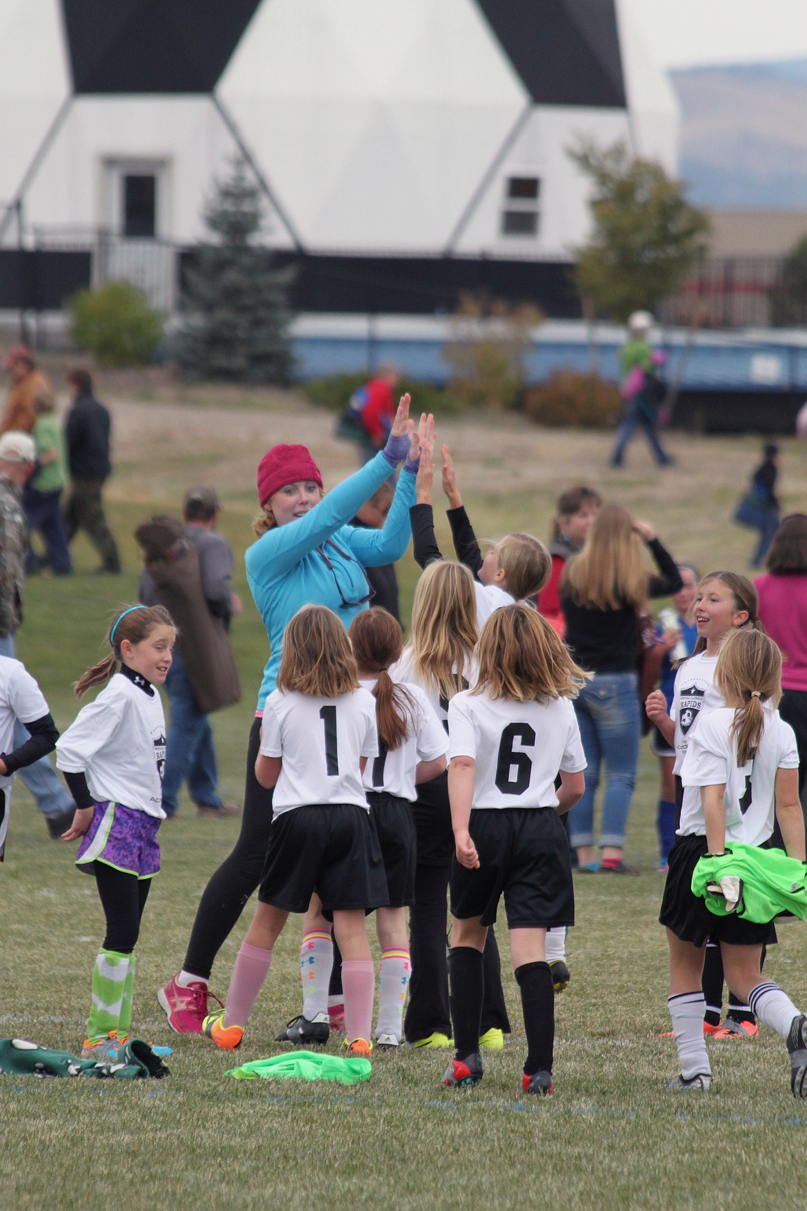 Whitefish youth soccer coach Kelsey Whitby with the young girls she coached for years before and after being diagnosed with an aggressive form of brain cancer. (Courtesy photo)