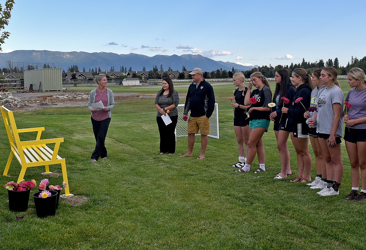 Betsy Funk, mother of Kelsey Whitby, far left, speaks at the dedication of the Kelsey Whitby Memorial Field and bench at Smith Fields. (Whitney England/Whitefish Pilot)