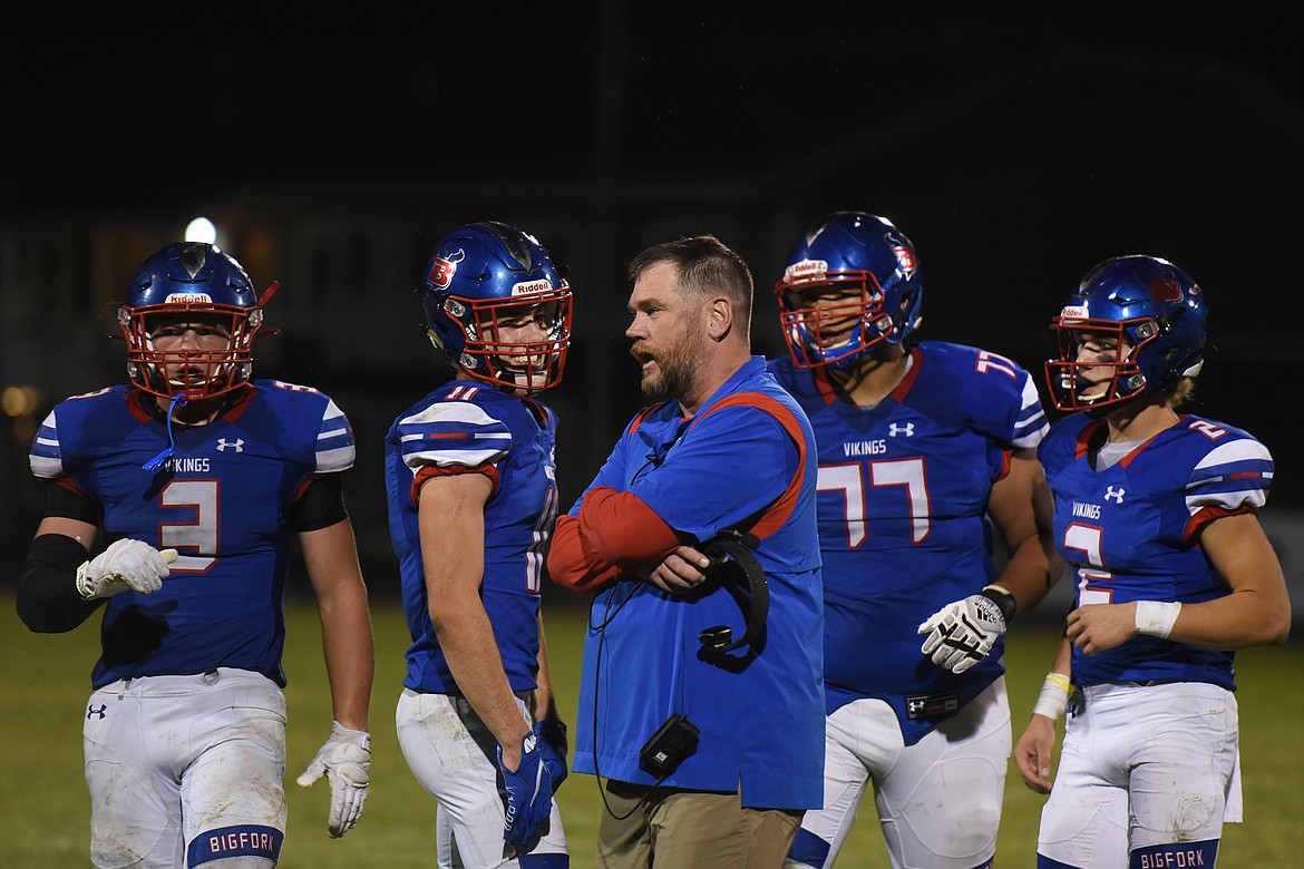 Bigfork head football coach Jim Benn consults with his team during a timeout late in the fourth quarter against Jefferson Friday. (Jeremy Weber/Bigfork Eagle)