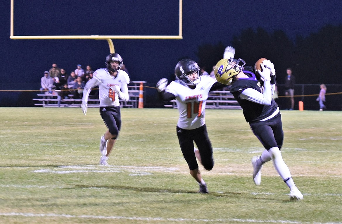 Polson receiver Colton Graham make an over-the-shoulder catch on a deep ball in front of Ronan defender Ted Coffman (14). (Scot Heisel/Lake County Leader)