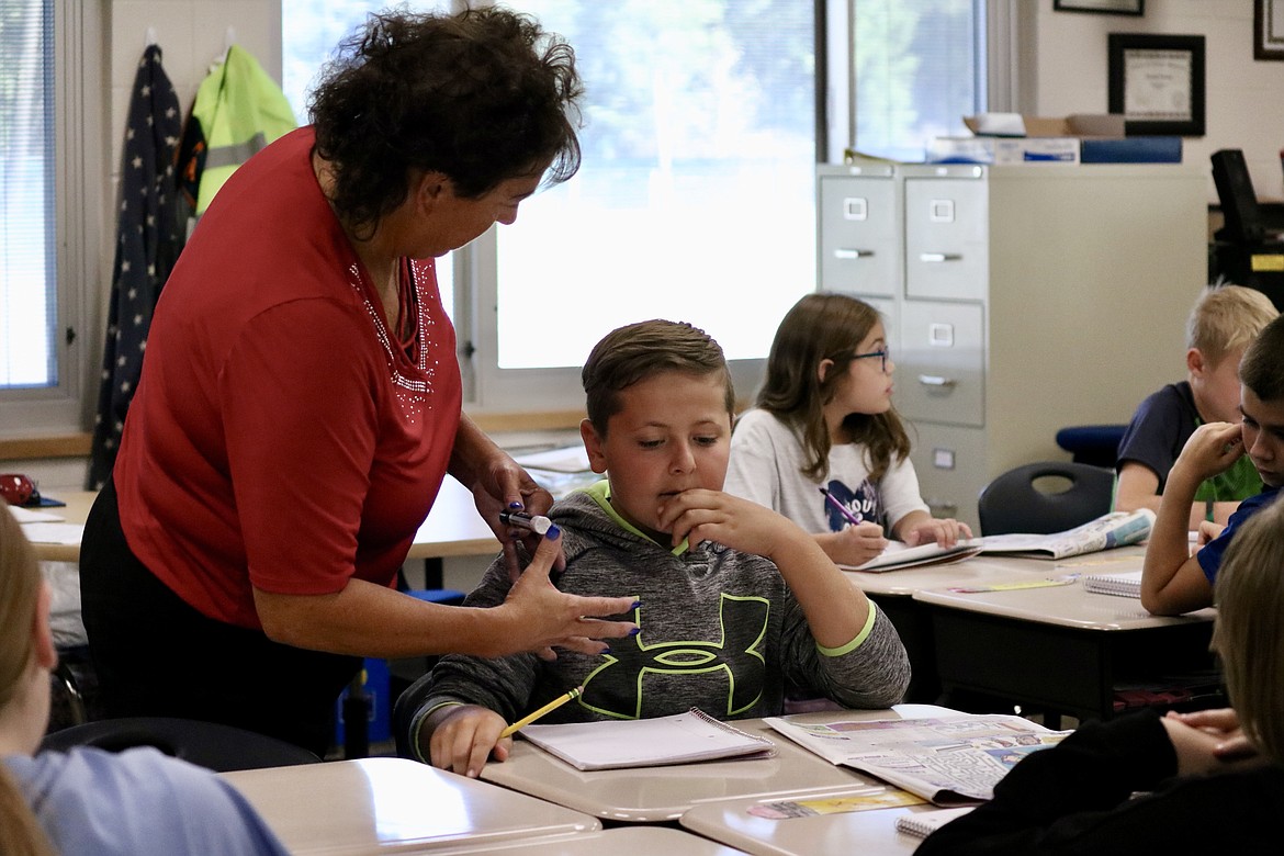 Fifth grade teacher Deanna Watkins helps 10 year old Dallen Wilding collect his ideas into a submission for Kid Scoop, a section of the newspaper for kids, at Twin Lakes Elementary school in Rathdrum. HANNAH NEFF/Press