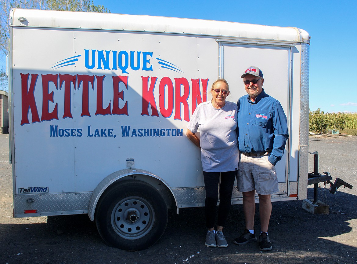 Jim and Karen Huff, owners of Unique Kettle Korn, stand outside their home in Moses Lake Monday beside their trailer used to haul their popper and booth to different venues.