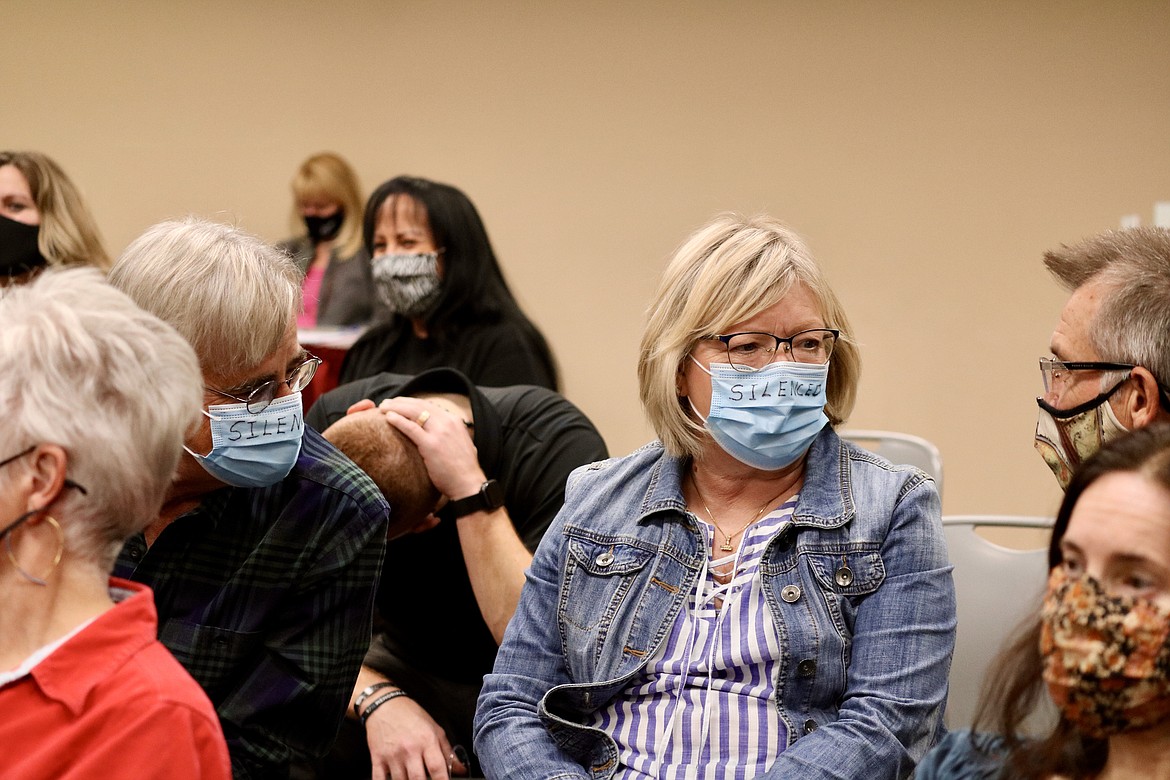 Former North Idaho College instructor Michelle Lippert and her husband Pat wear masks with the word "silence" to show their protest against the removal of public comment from the meeting agenda by Board of Trustees chair Todd Banducci at the board meeting on Wednesday. HANNAH NEFF/Press