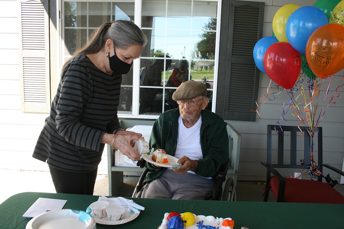 Dr. Jim Young gets some ice cream added to his plate of birthday cake by his daughter Nancy Young at his 103rd birthday party Sept. 20.