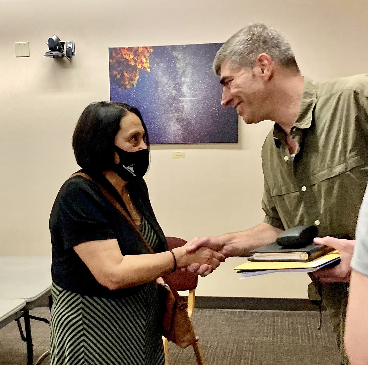 North Idaho College board chair Todd Banducci congratulates Lita Burns, acting President and former Vice President of Instruction, at the board meeting Friday afternoon at NIC during which Burns was officially appointed. HANNAH NEFF/Press