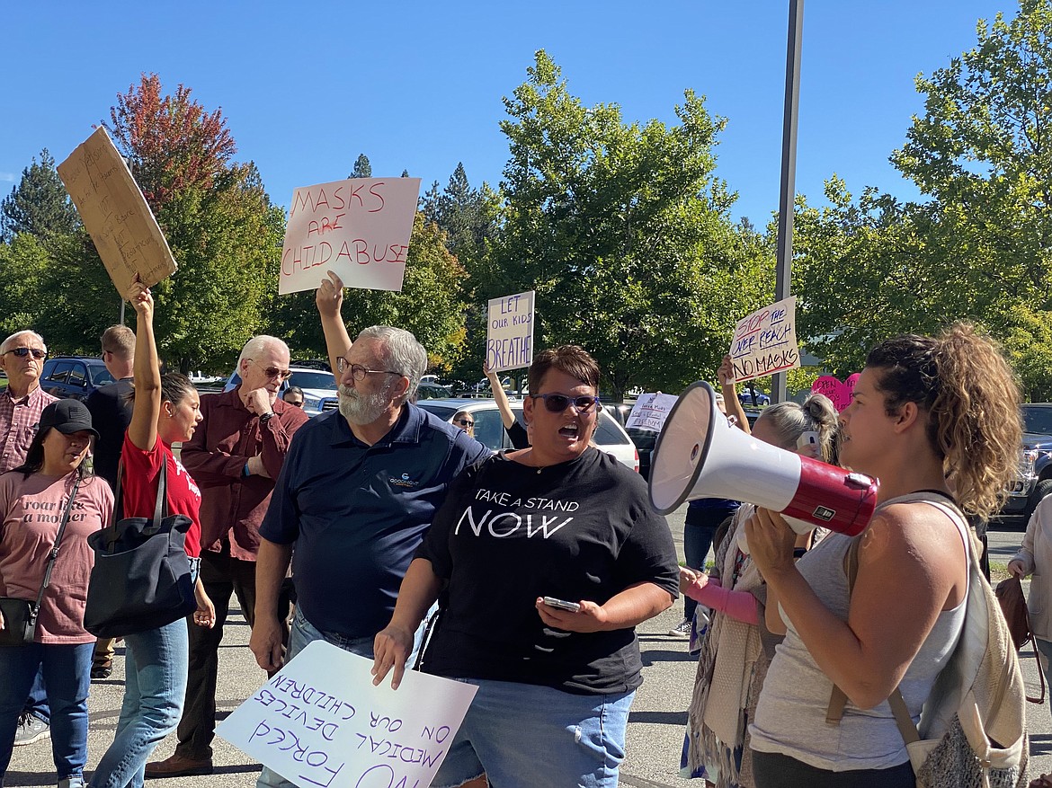 Nearly 200 people protesting a possible mask mandate shut down a special Coeur d'Alene School Board meeting Friday. Here, individuals in the crowd yell their grievances at the district office after moving from the original meeting location. (MADISON HARDY/Press)