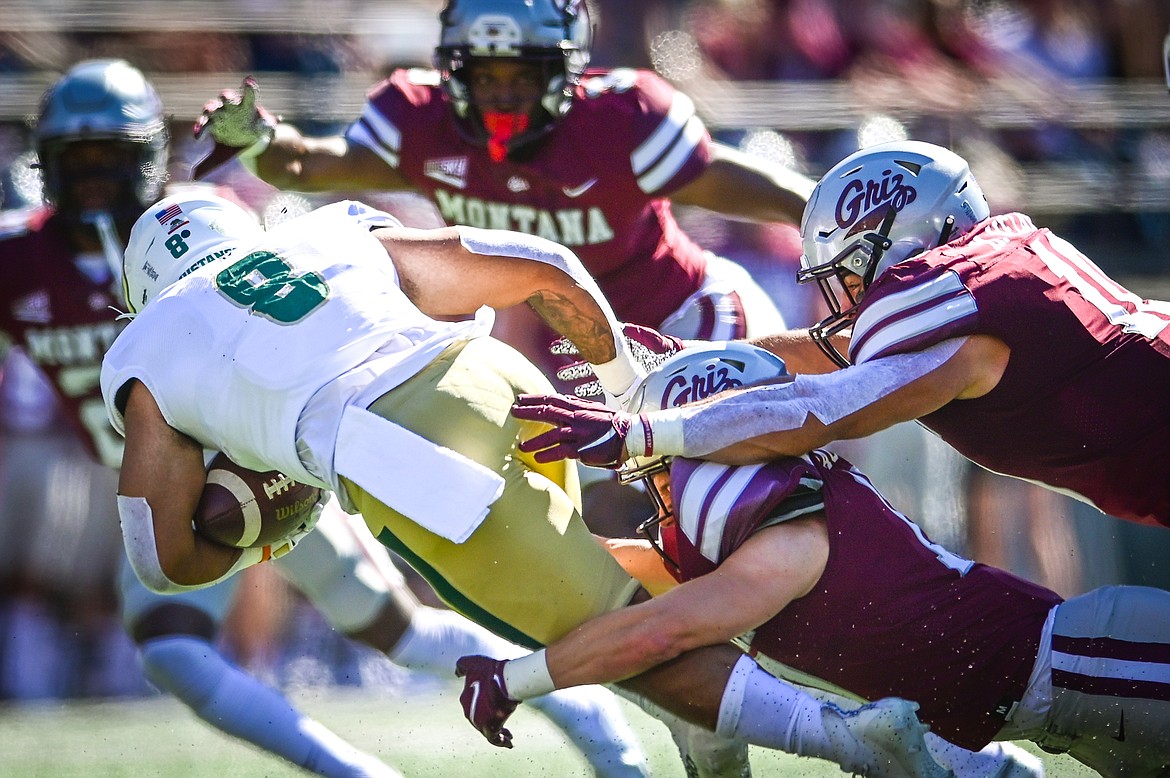 Montana defenders Robby Hauck (17) and Marcus Welnel (10) stop Cal Poly running back Shakobe Harper (8) in the first quarter at Washington-Grizzly Stadium on Saturday, Sept. 25. (Casey Kreider/Daily Inter Lake)