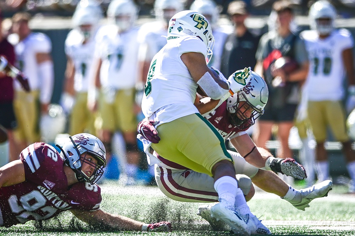 Montana defenders Jacob McGourin (92) and Jace Lewis stop Cal Poly Shakobe Parker (8) in the first quarter at Washington-Grizzly Stadium on Saturday, Sept. 25. (Casey Kreider/Daily Inter Lake)