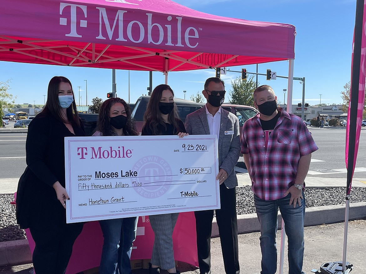 From the left, Downtown Moses Lake Association Treasurer Denise Kindler, DMLA President Rosenda Henley, DMLA Executive Director Lexi Smith, Moses Lake Mayor David Curnel and T-Mobile Senior Manager for SMRA Sales Geoff Dean pose with a giant check for $50,000 T-Mobile donated to the DMLA on Thursday to help fund the association’s downtown business incubator.